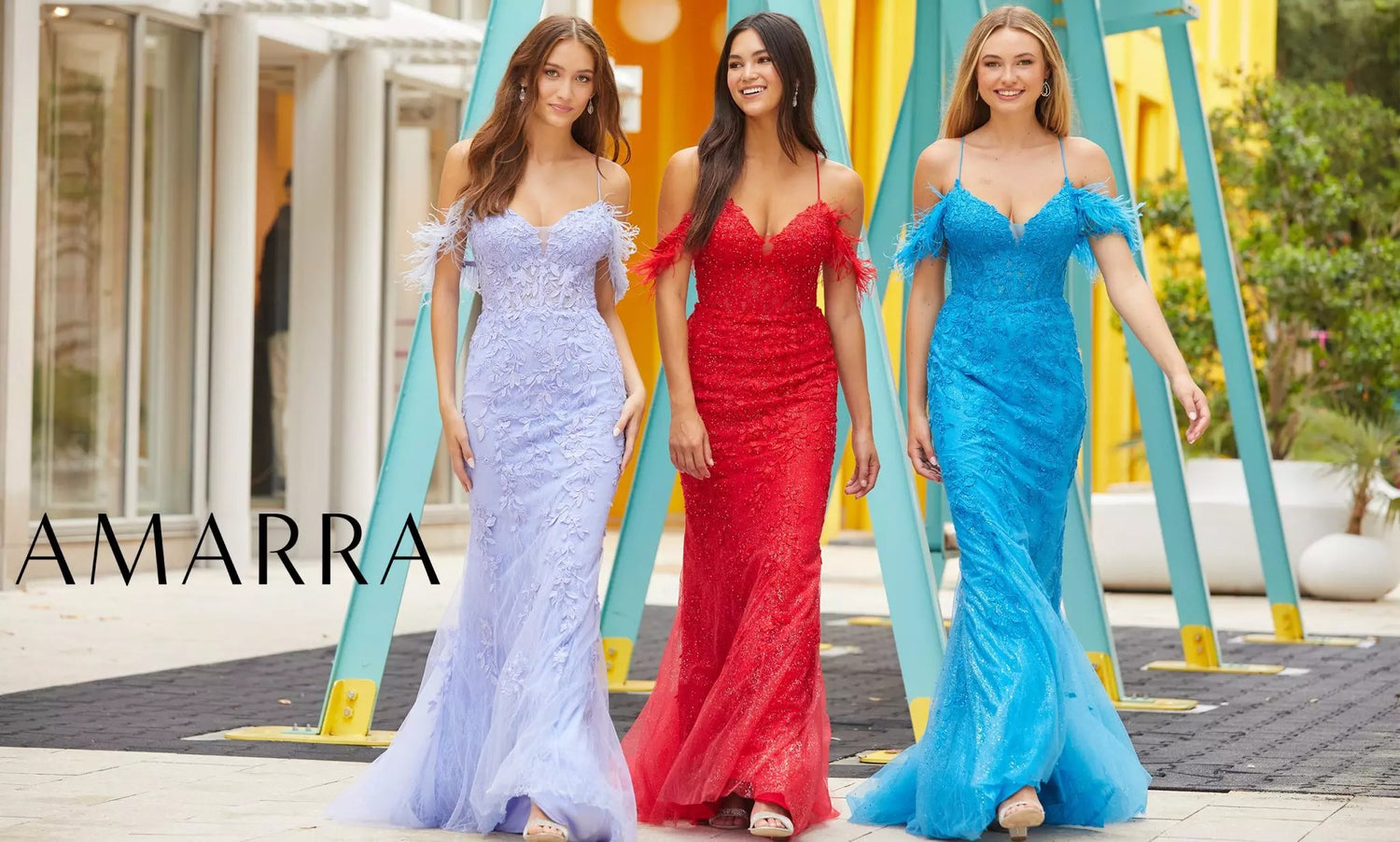 Three models in lilac, red and blue lace mermaid gowns with feathered off-shoulder straps