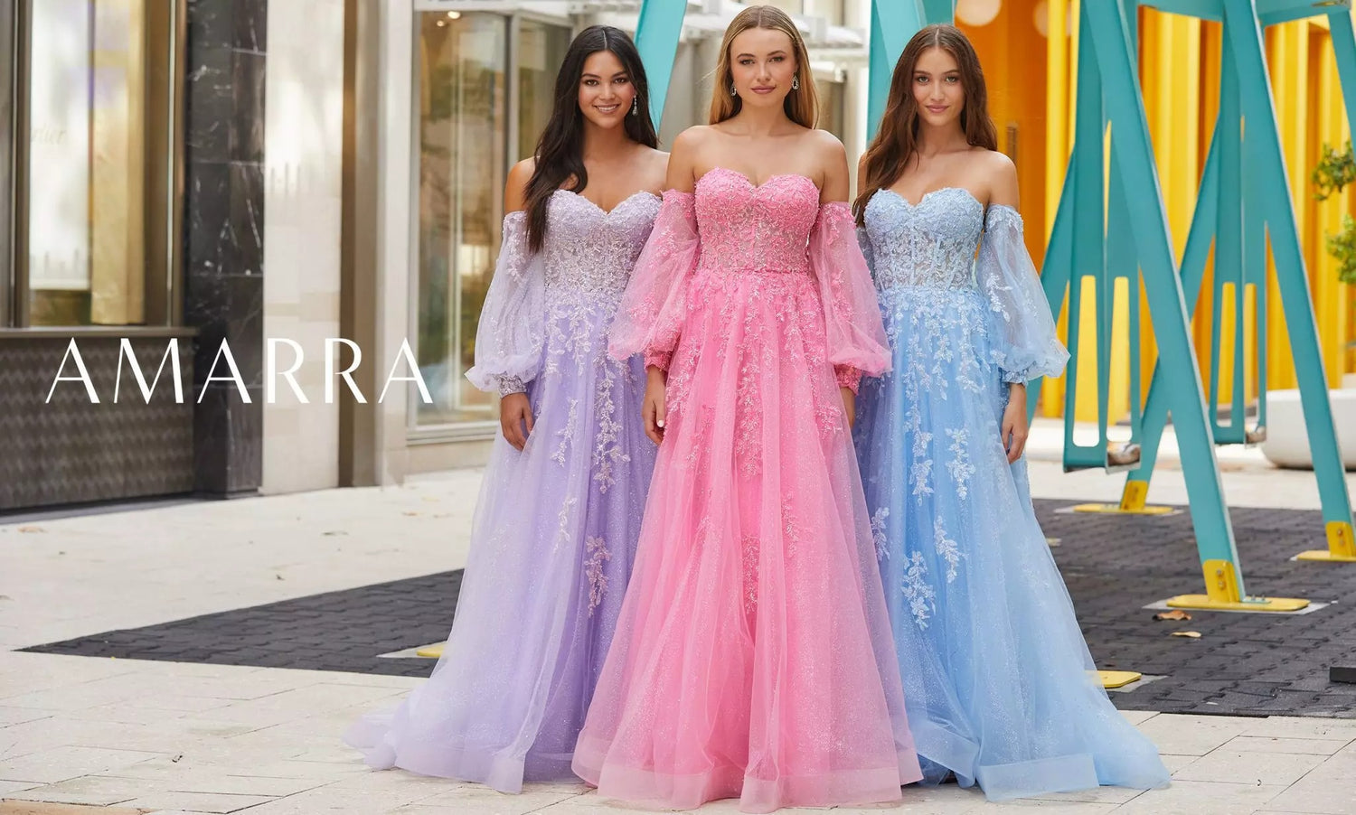 Three models in lilac, pink and blue floral-appliqué ball gowns with sheer puff sleeves