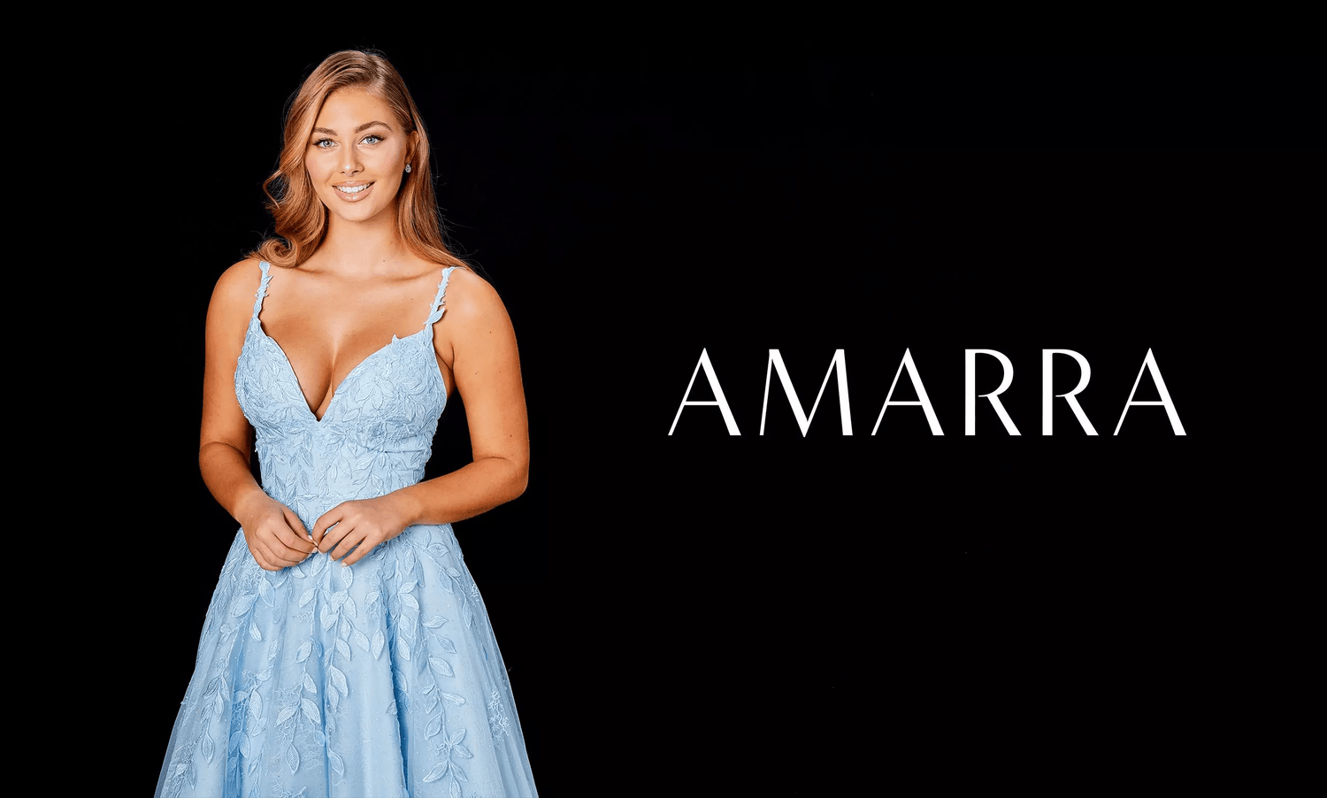 Blonde model in a light blue lace A-line gown with V neckline on black background