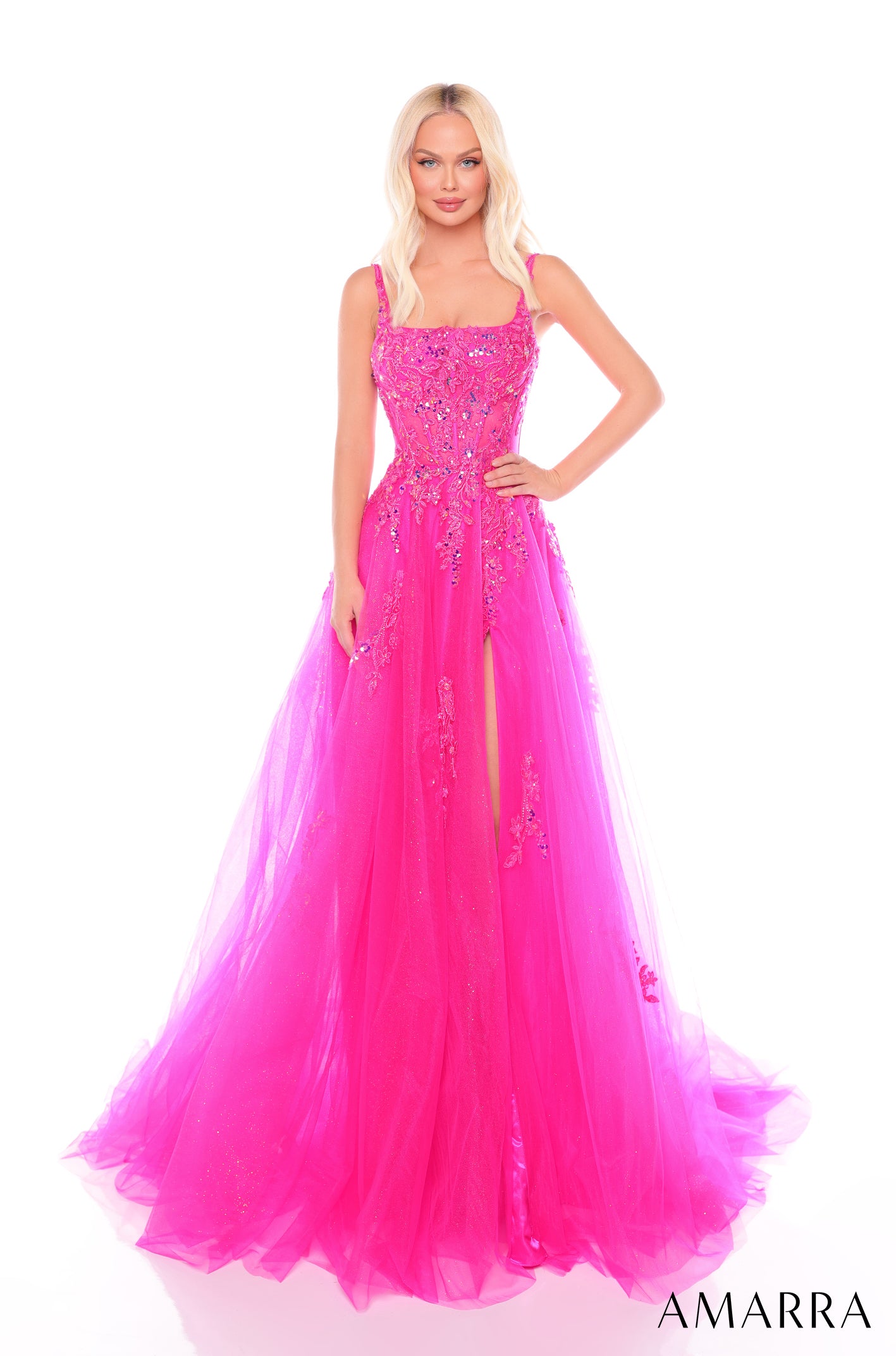 A floor-length fuchsia gown with embellished bodice and tulle skirt, featuring a high slit and thin straps.