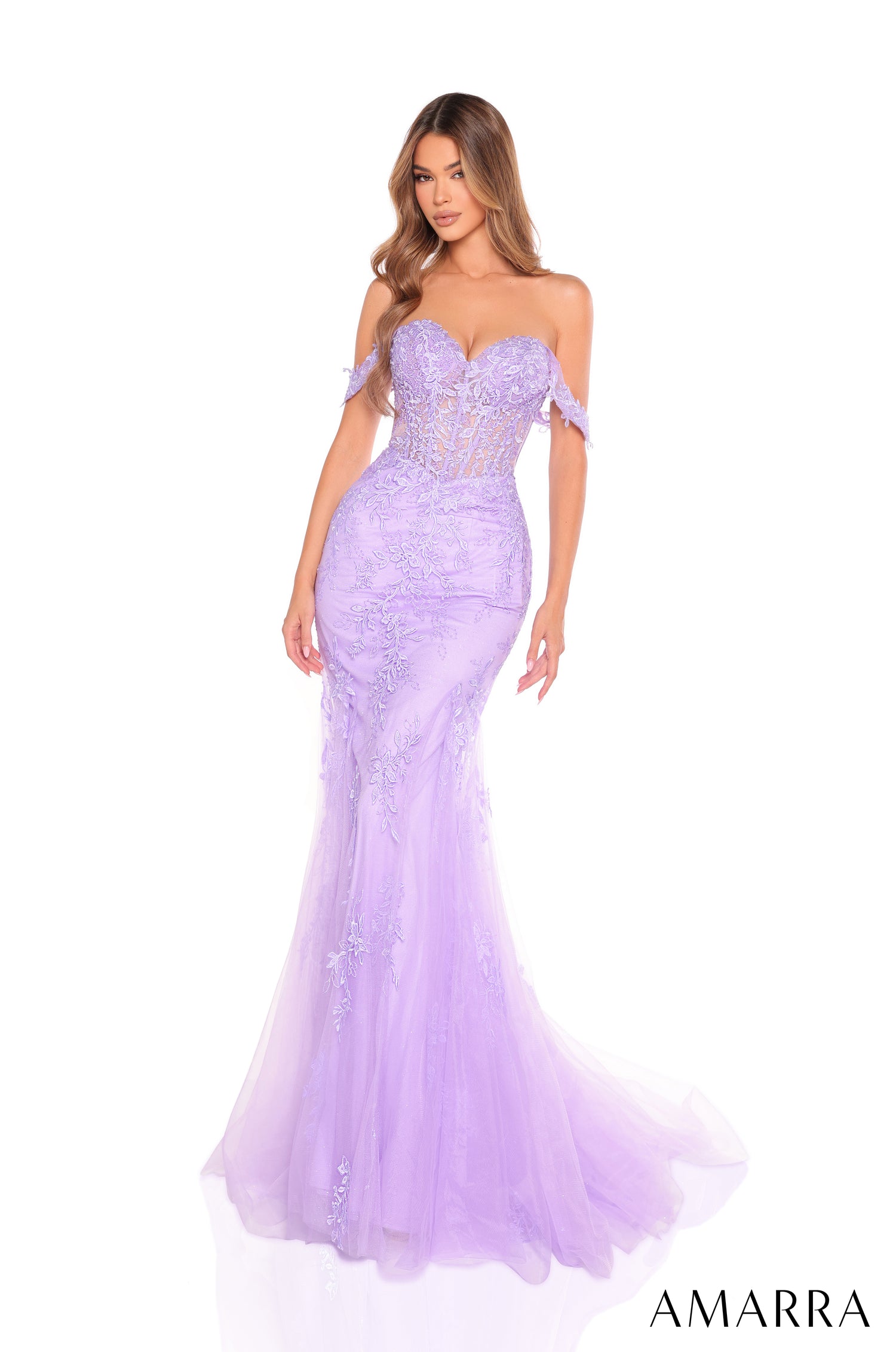 A model wears a lilac mermaid-style evening gown with delicate off-shoulder lace details and a sweeping tulle skirt.