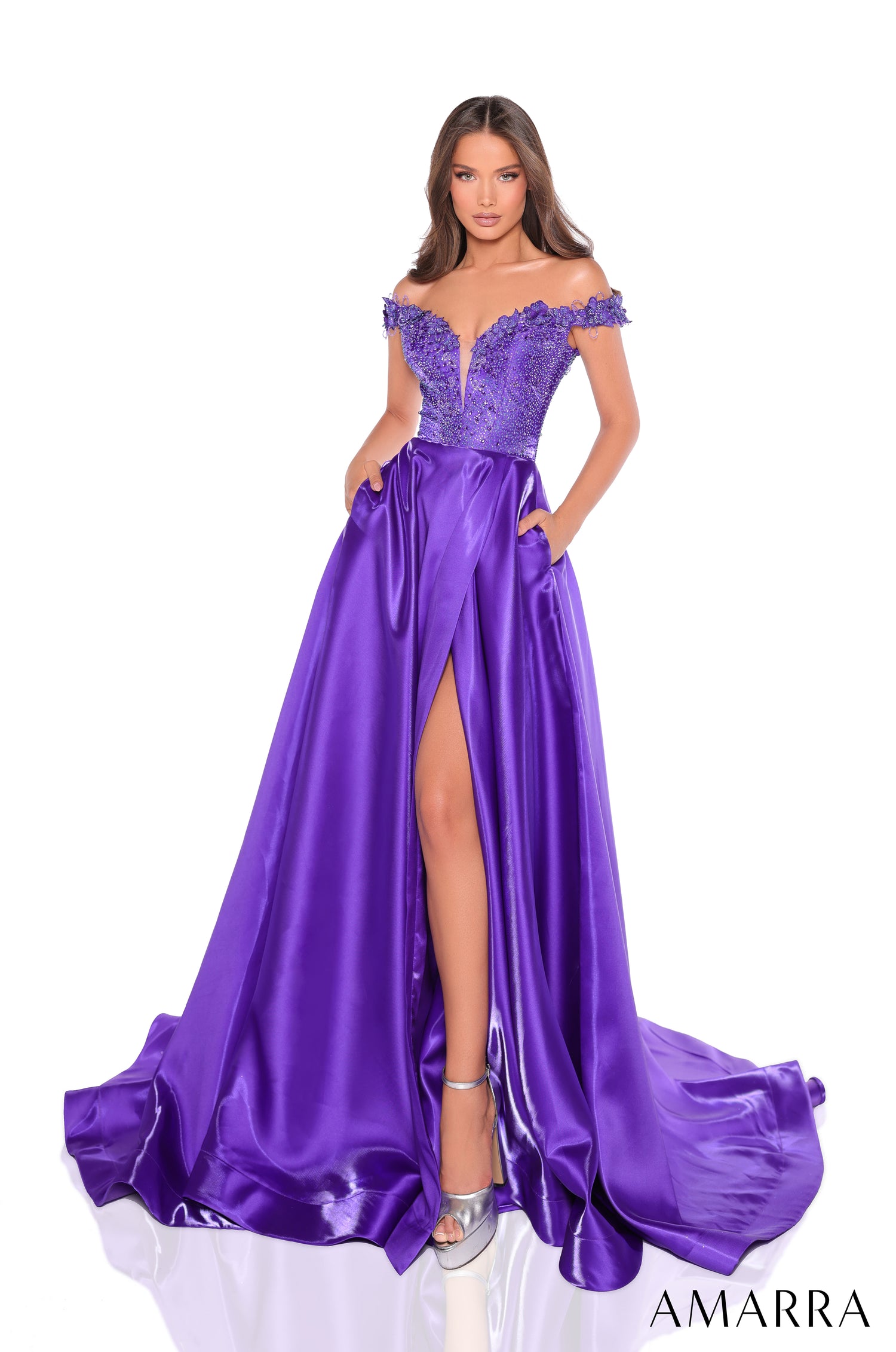 A long purple satin evening gown with an off-shoulder beaded bodice and high leg slit, styled on a model.