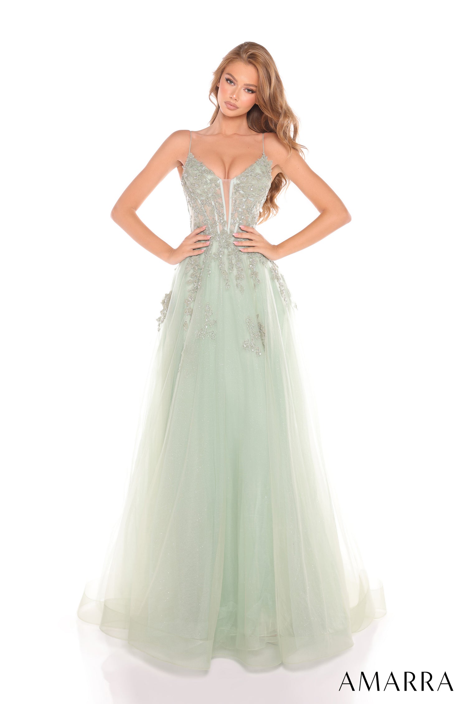 A floor-length sage ballgown with a beaded bodice and tulle skirt, styled on a model with wavy hair.