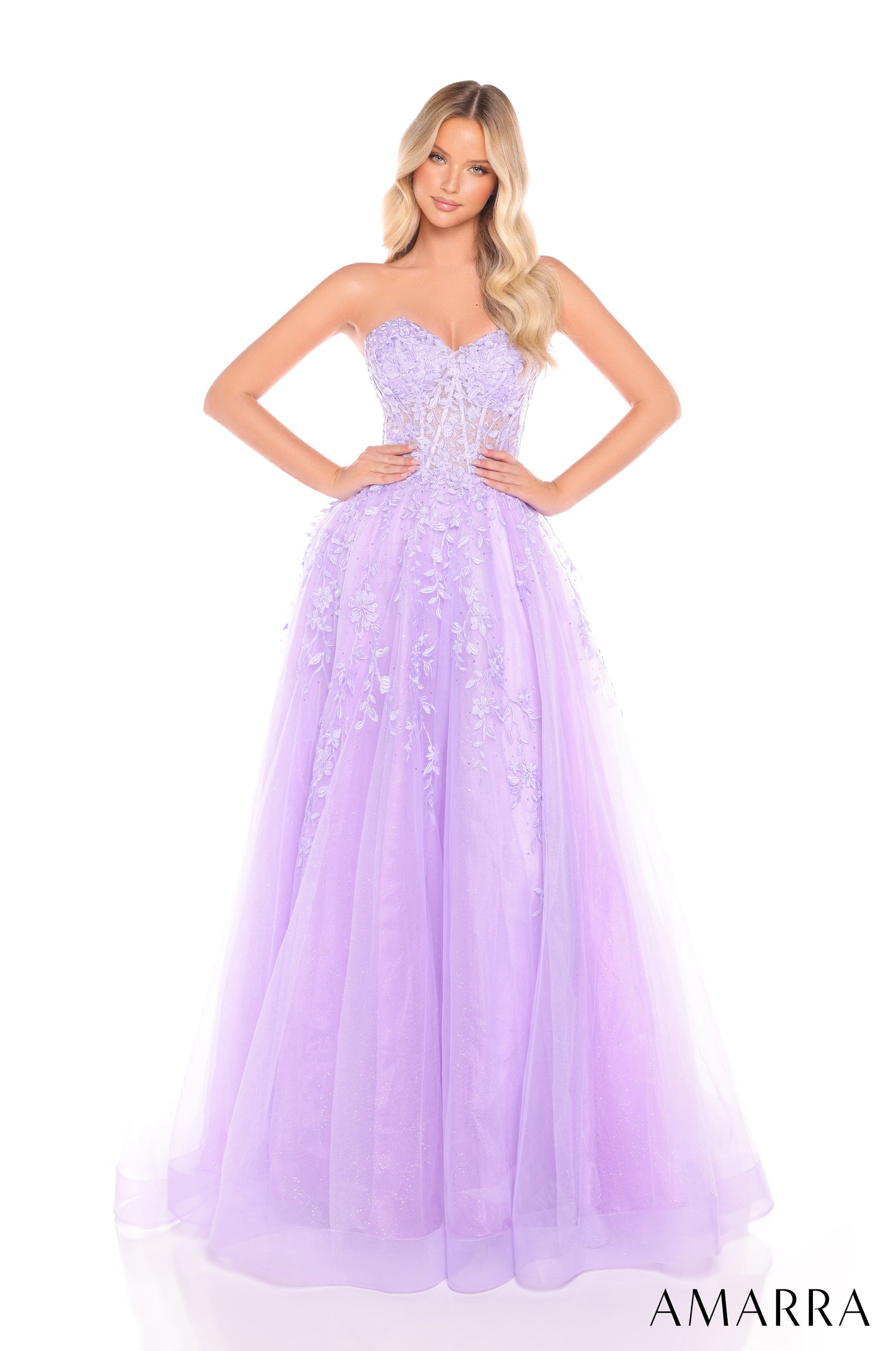 A woman wears a lilac sweetheart ballgown with floral embroidery and a full tulle skirt.