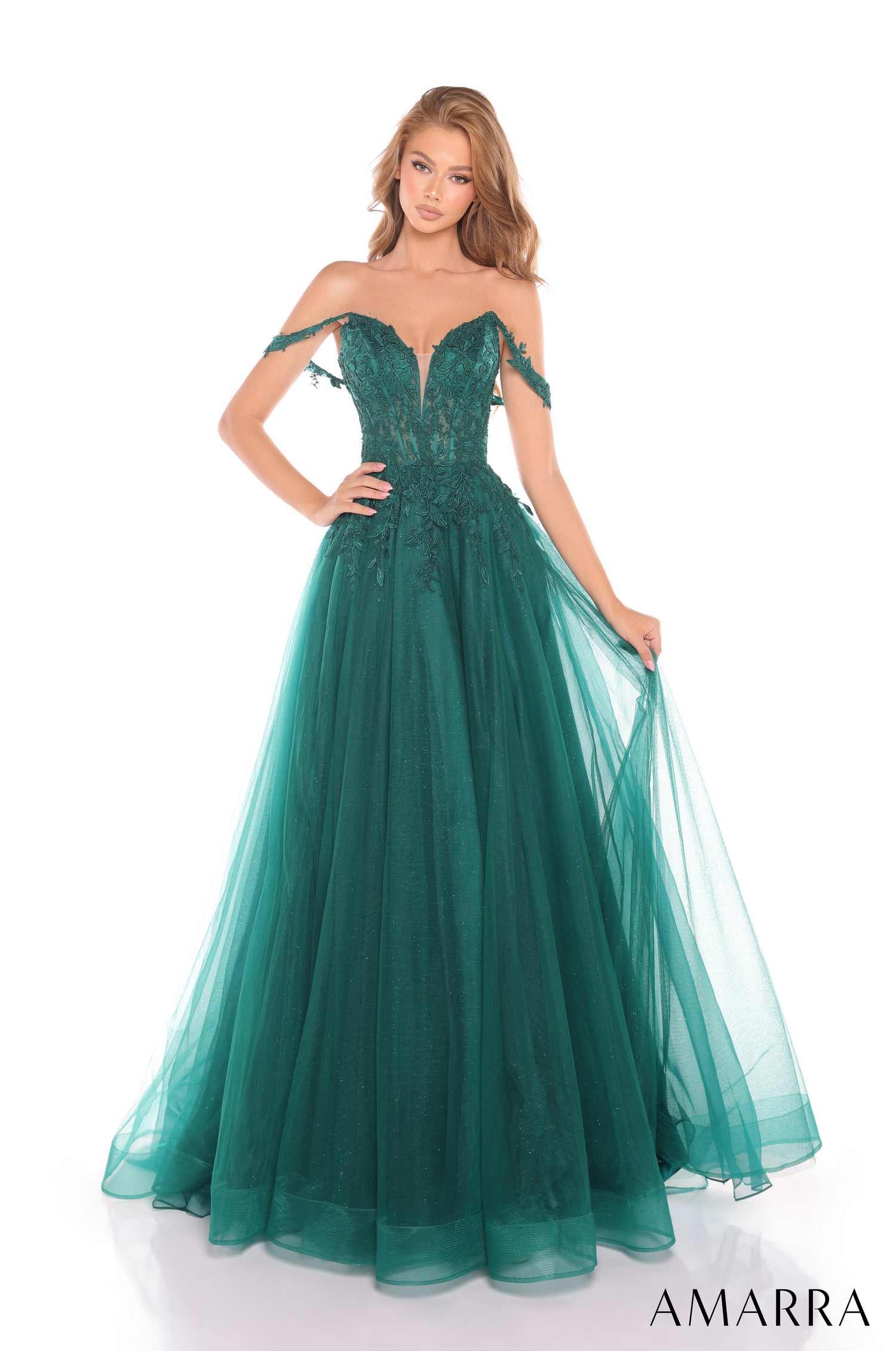 An off-shoulder emerald gown with lace bodice and flowing tulle skirt, styled on a model against a white background.