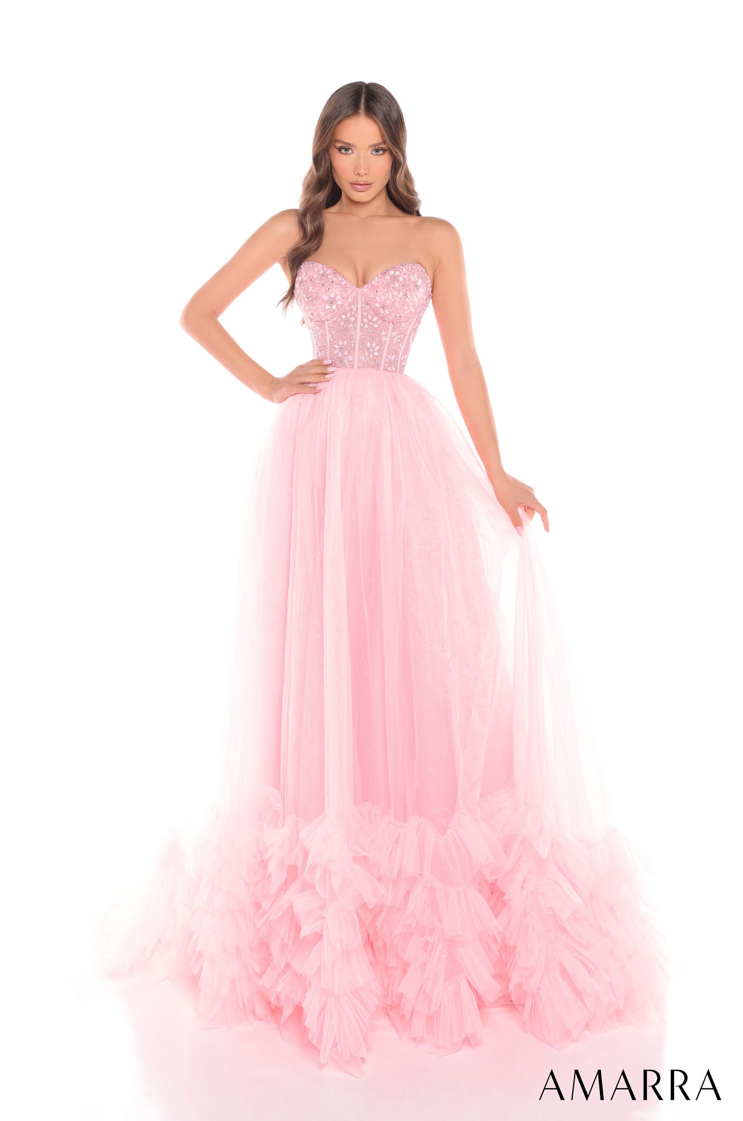 A model wears a strapless Light Pink gown with a beaded bodice and ruffled, flowing tulle skirt.