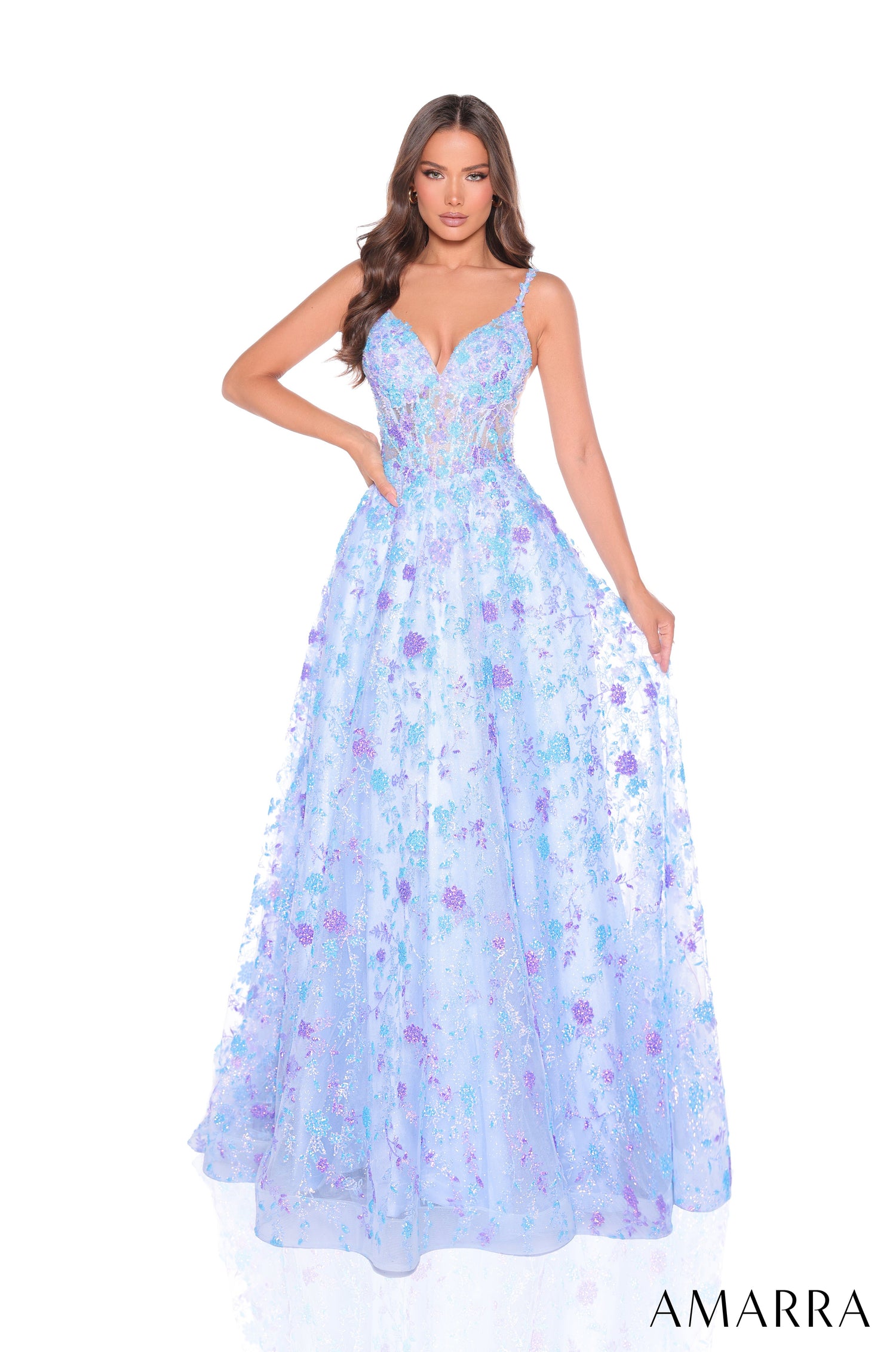 A model wears a flowing Light Blue/Lilac floral ball gown with spaghetti straps and an embellished bodice.