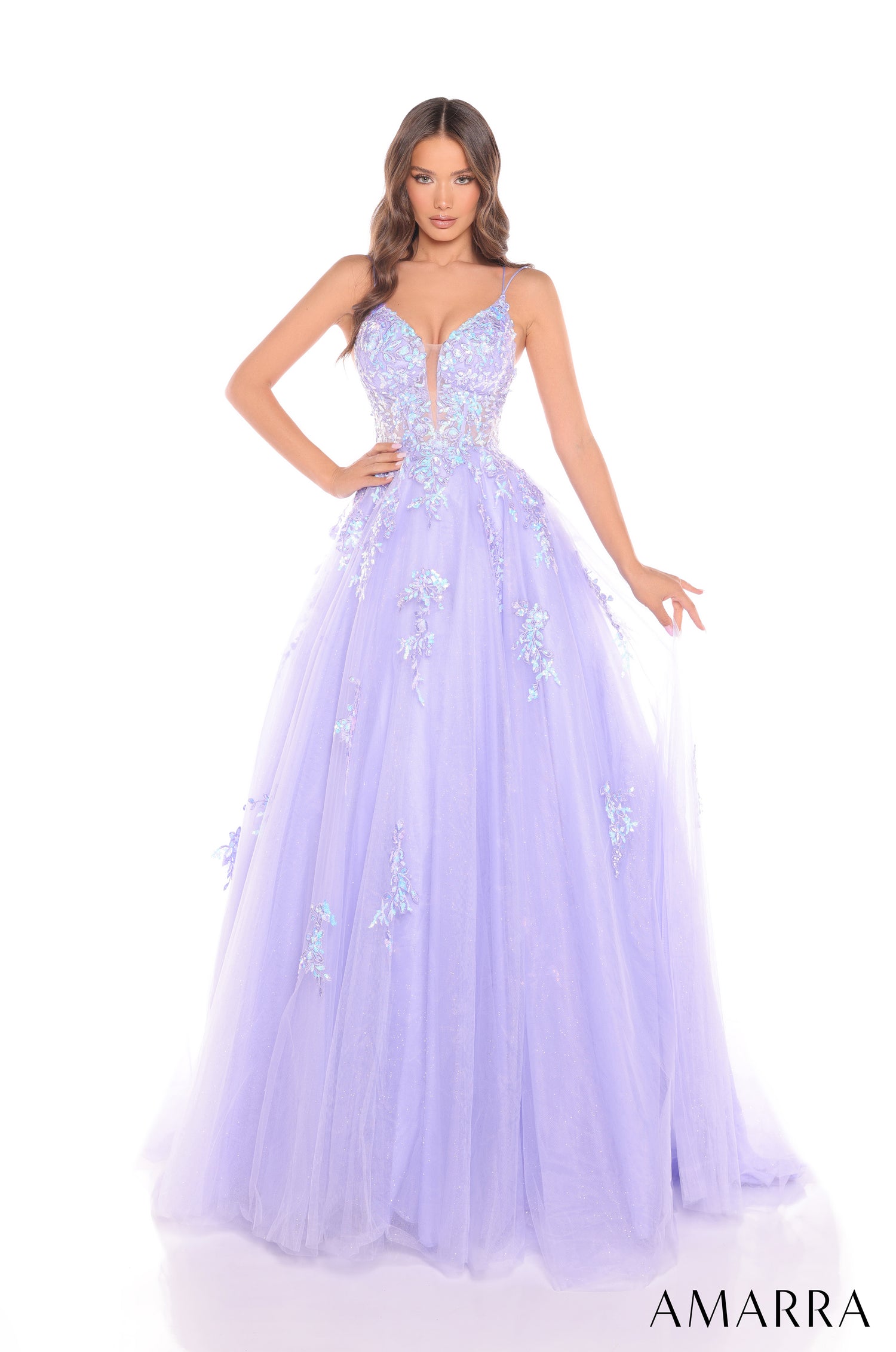 A model wears a periwinkle tulle ball gown with floral embellishments and a plunging sweetheart neckline.