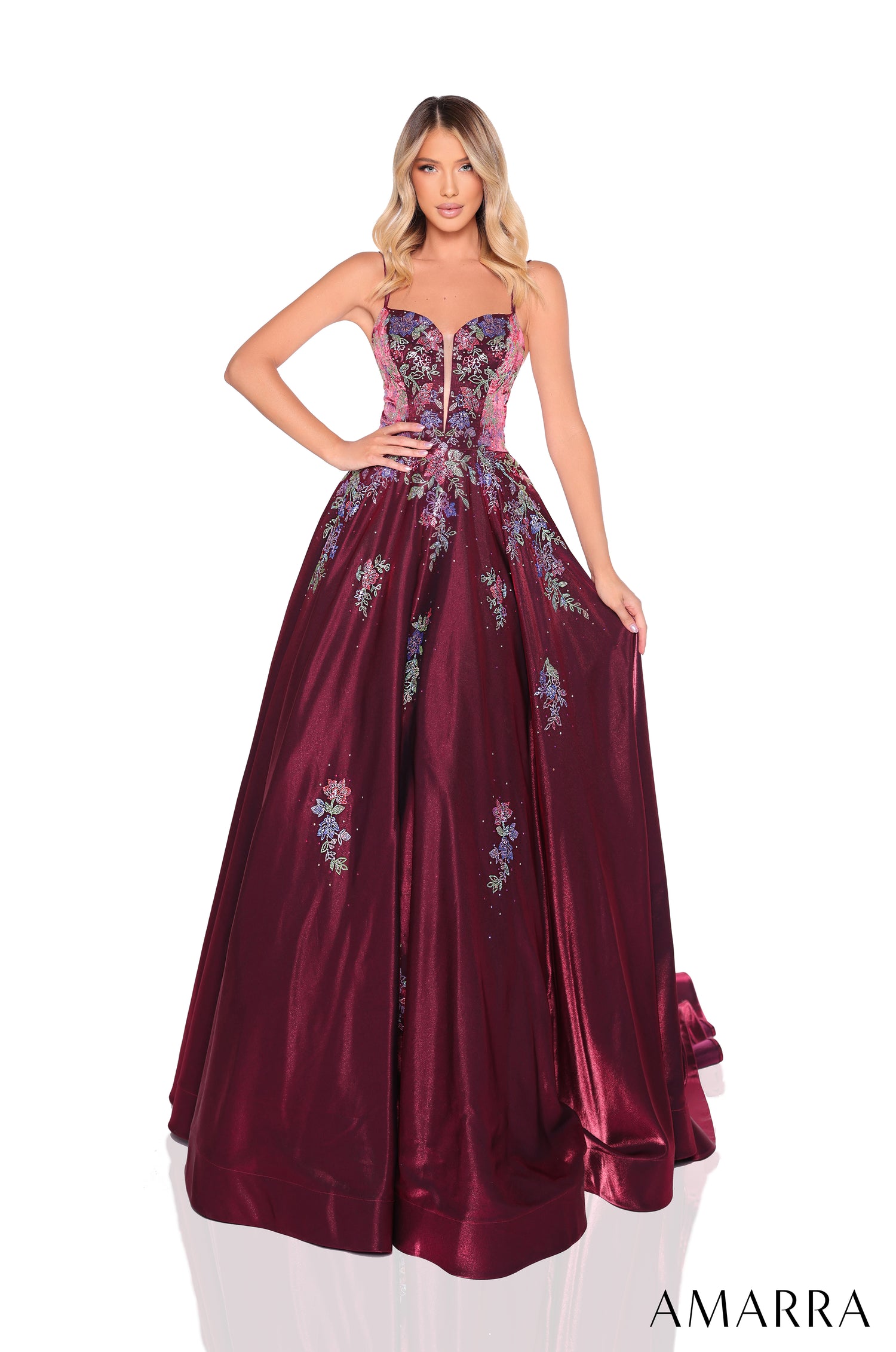 A woman wears a wine-colored ball gown with floral embroidery and a sweetheart neckline.