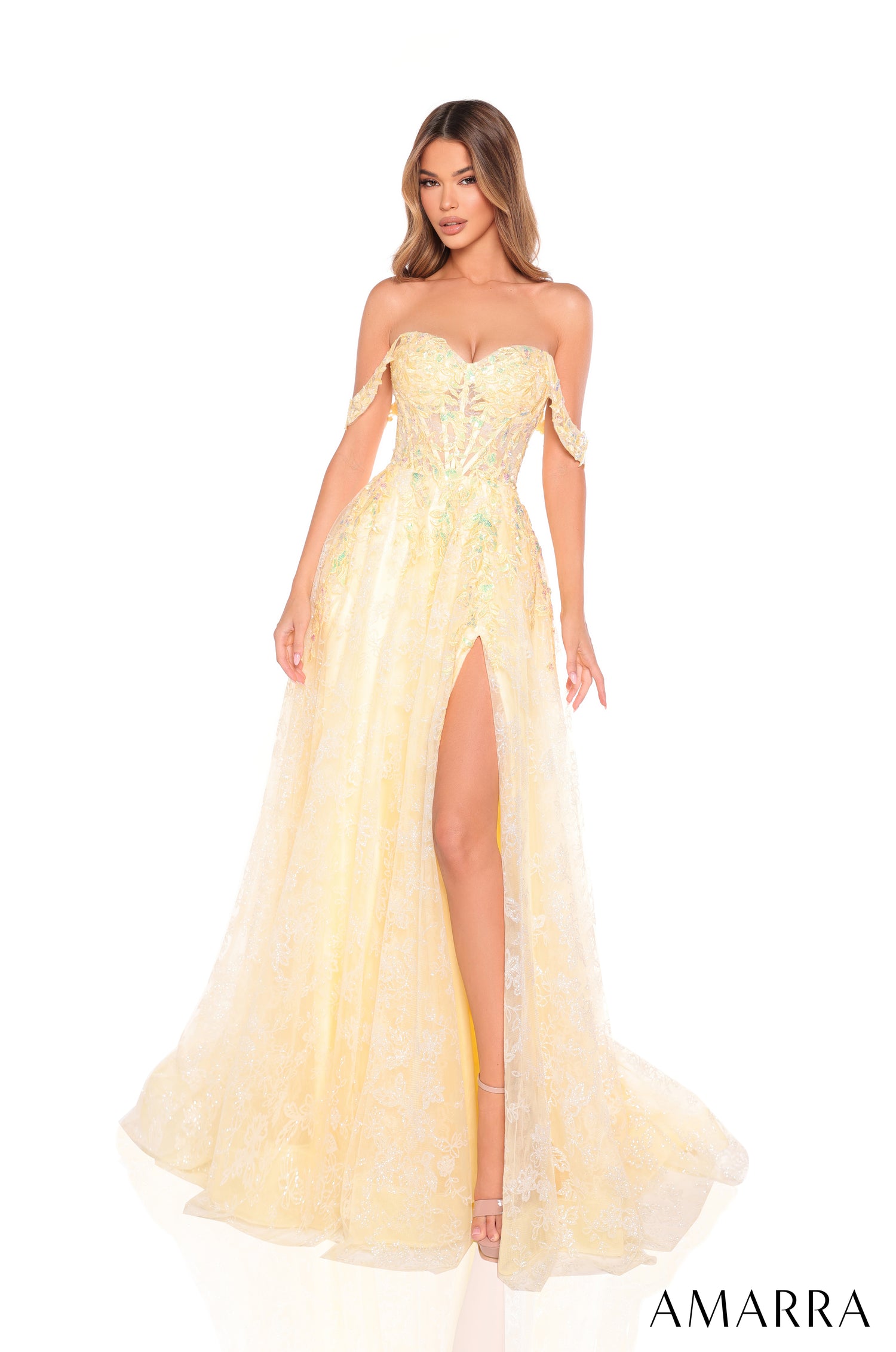 A model wears a light yellow off-shoulder gown with lace details and a high side slit.