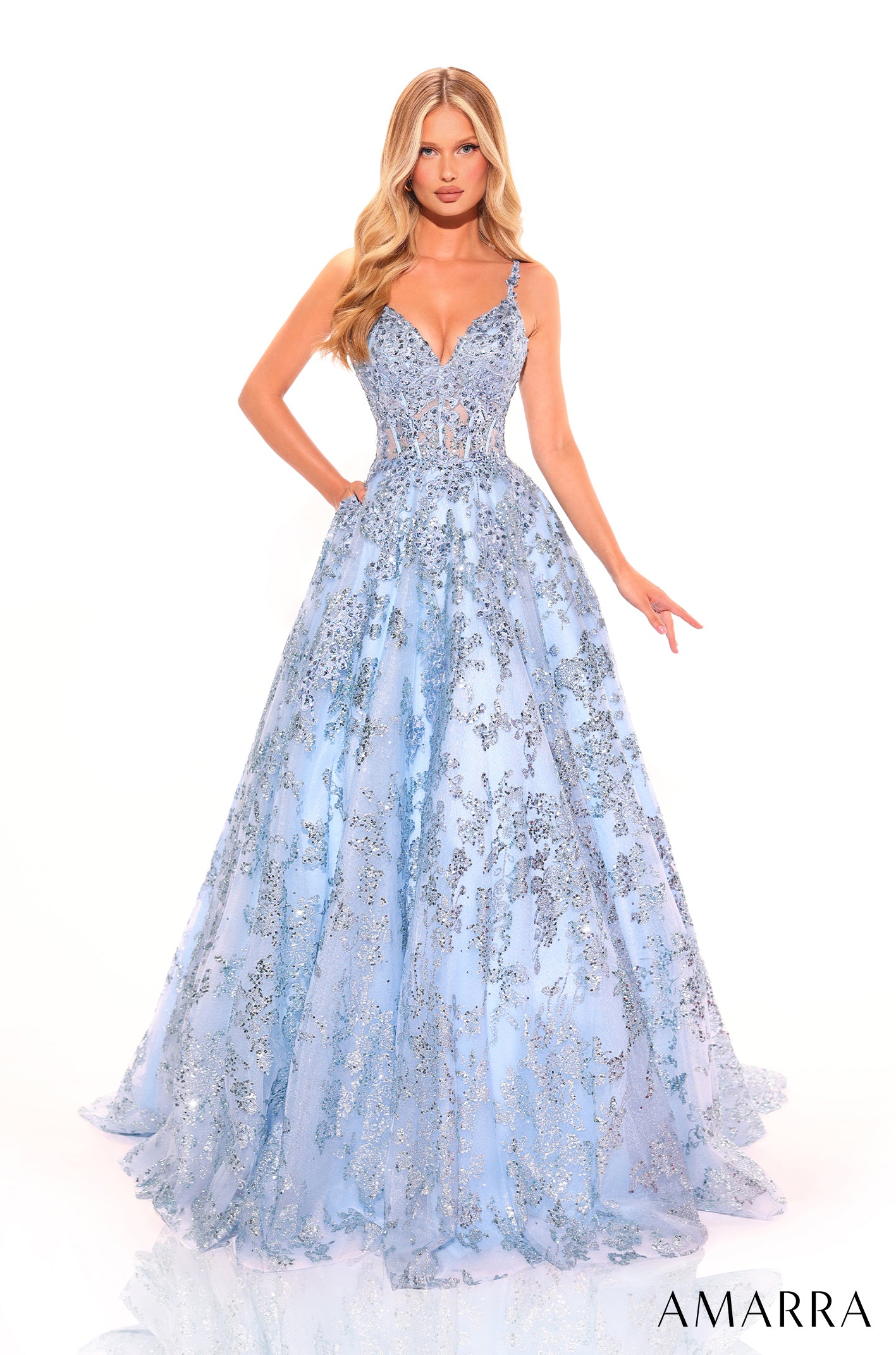 A model wears a light blue, floor-length ball gown with sparkling sequin embellishments and a sweetheart neckline.