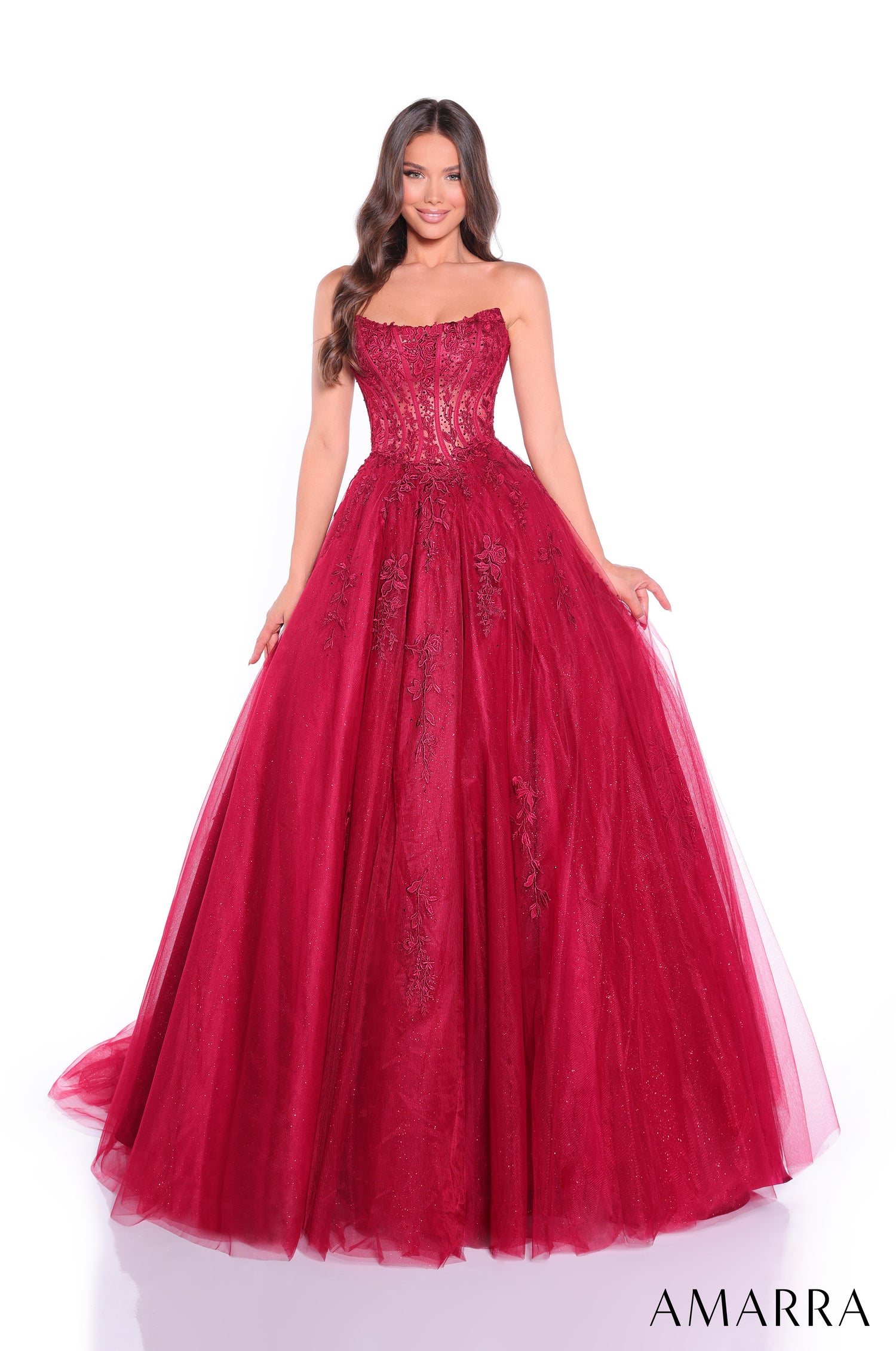 A strapless wine-colored ball gown with intricate floral lace and a full, flowing tulle skirt.