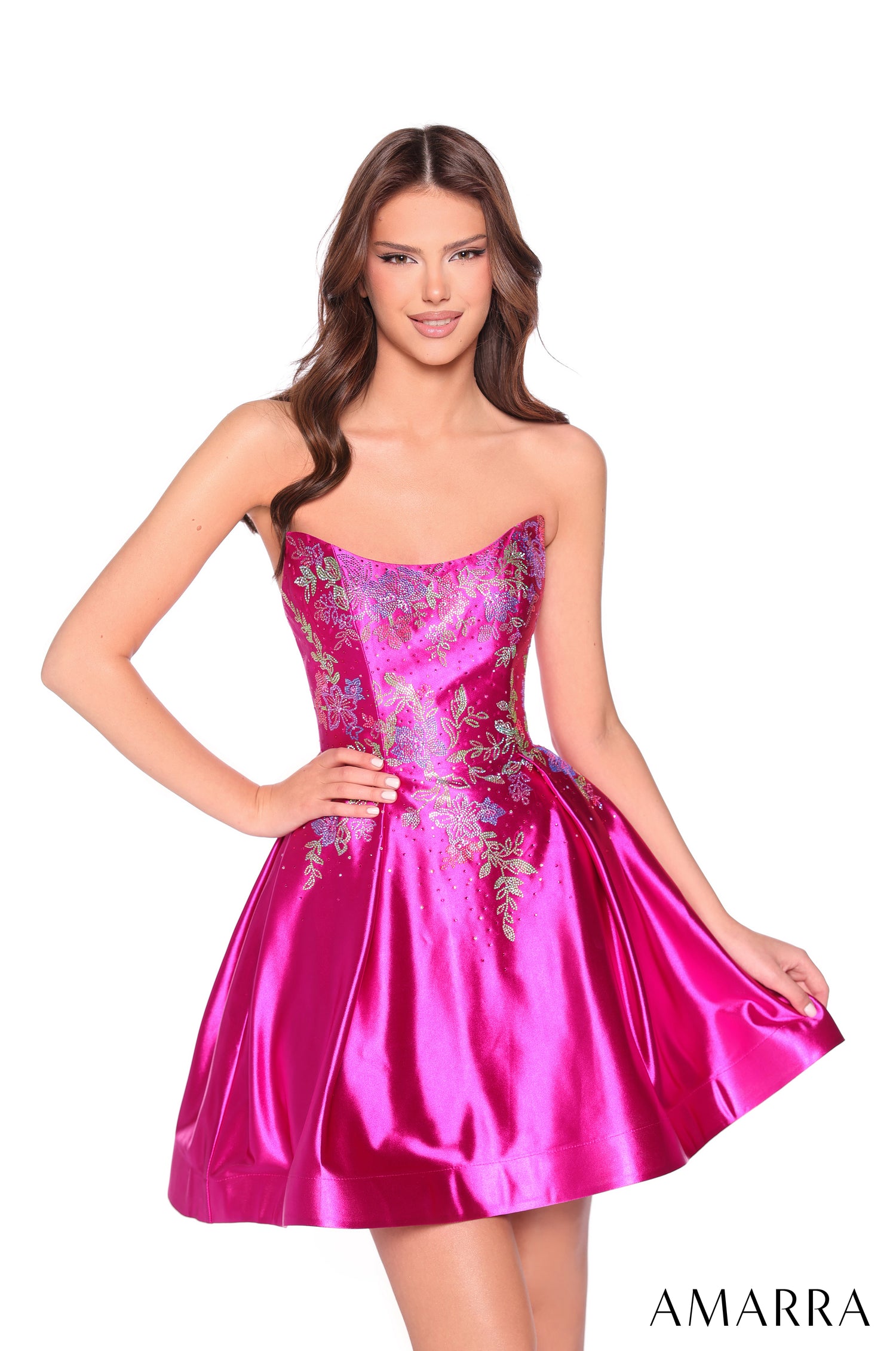 A model wears a strapless, fuchsia satin dress with shimmering leaf-embroidered bodice by Amarra.