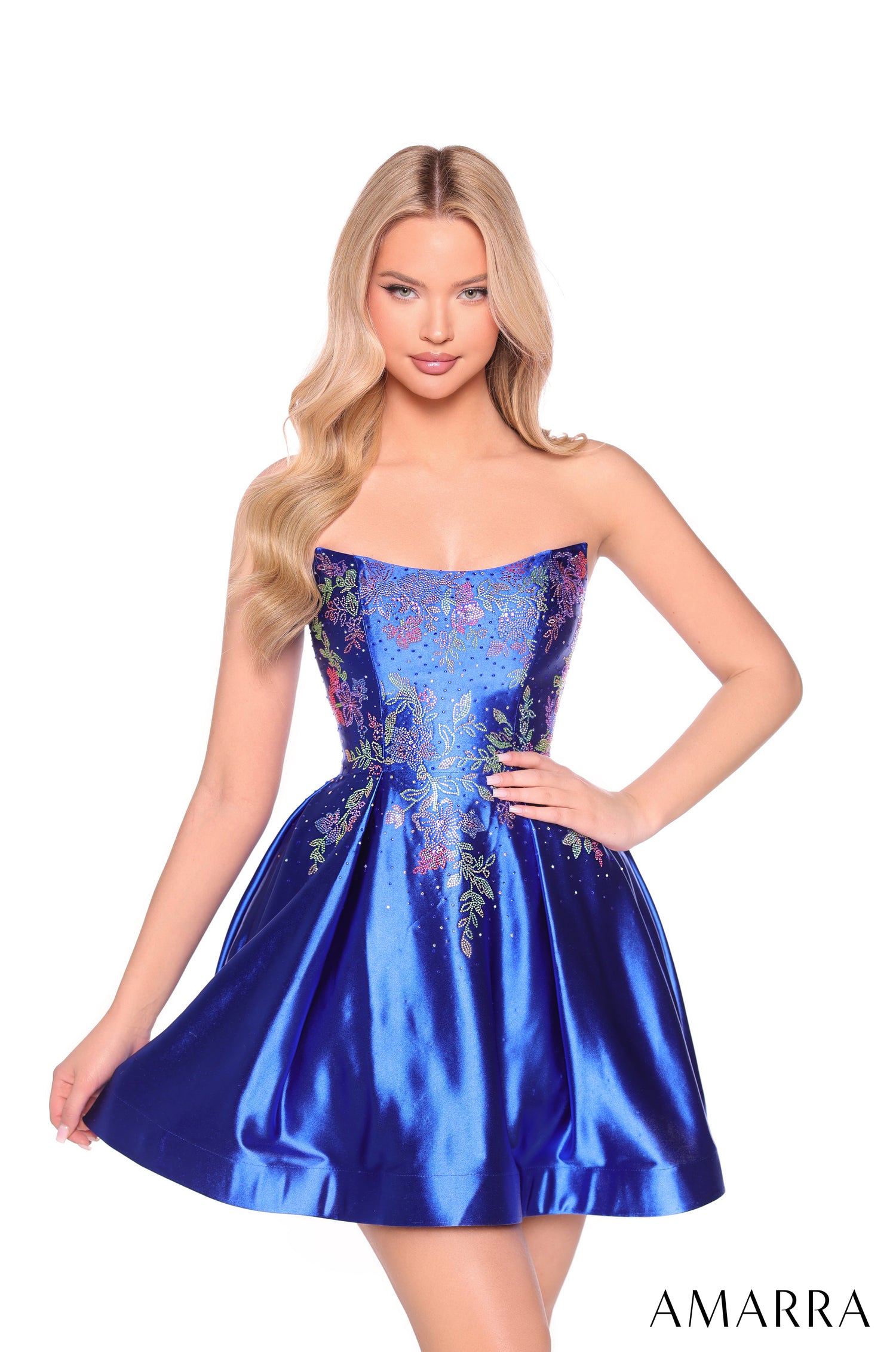 A model wears a strapless, embellished Royal Blue satin party dress with floral details and a full skirt.