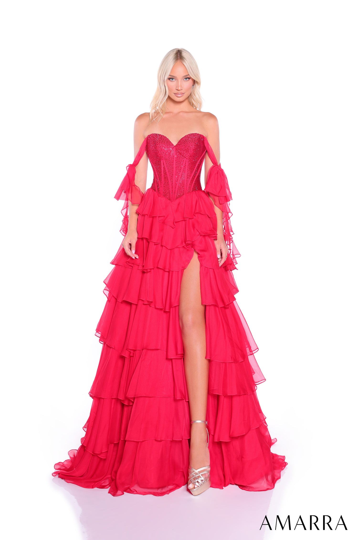 A strapless Red gown with a corset bodice, dramatic ruffled tiers, high leg slit, and flowing off-shoulder sleeves.