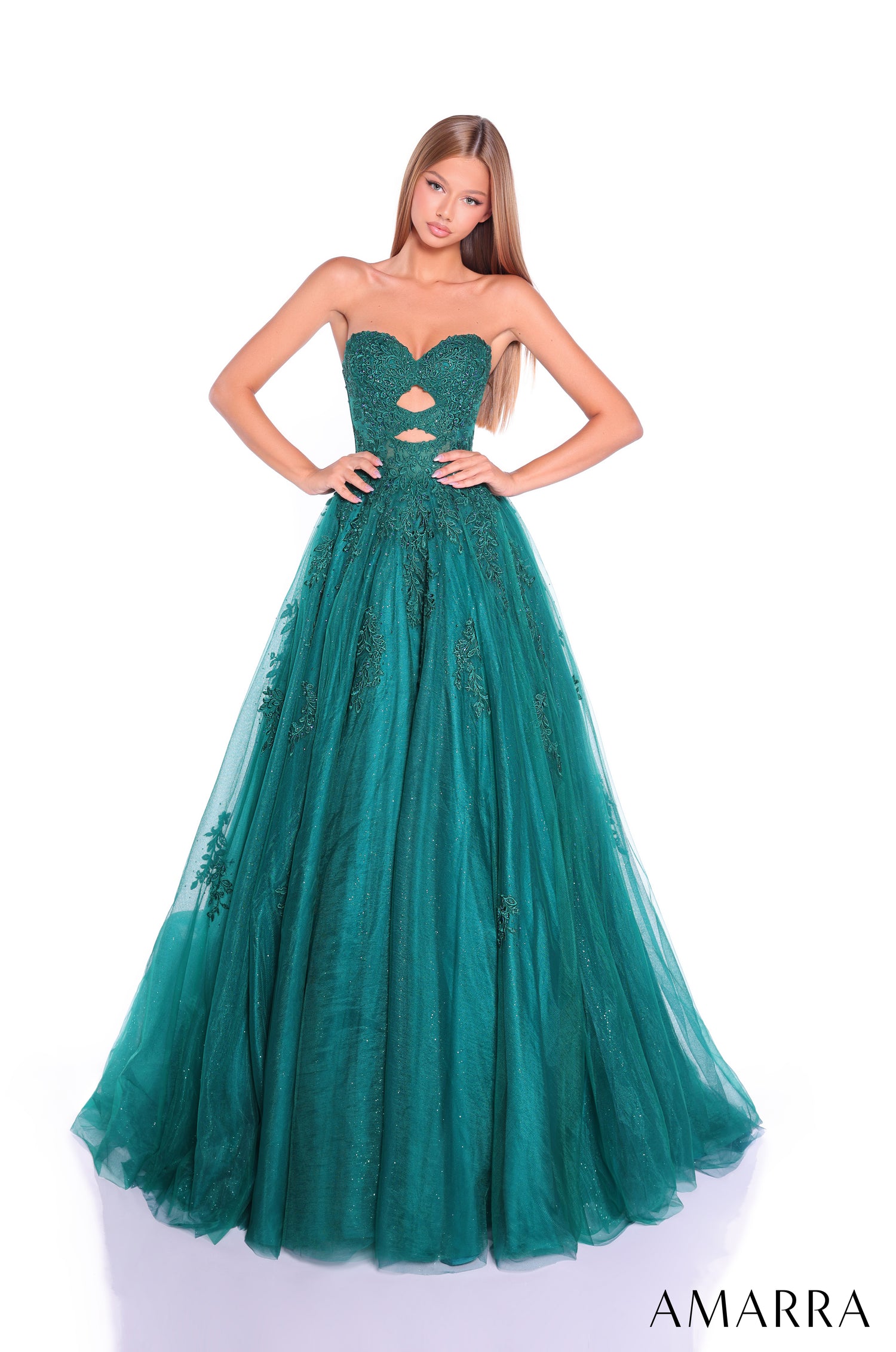 A floor-length emerald green strapless ball gown with lace details and a cutout bodice, styled on a model.