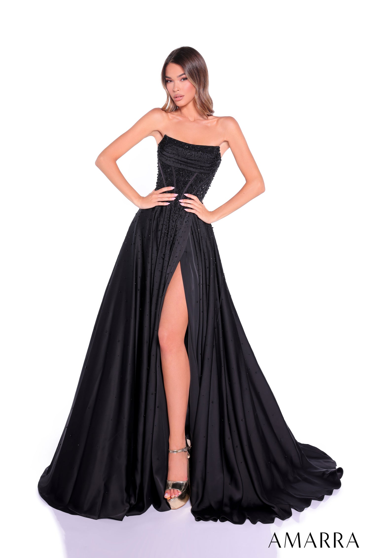 A strapless Black evening gown with a high slit and sparkling bodice, worn by a model striking a pose.
