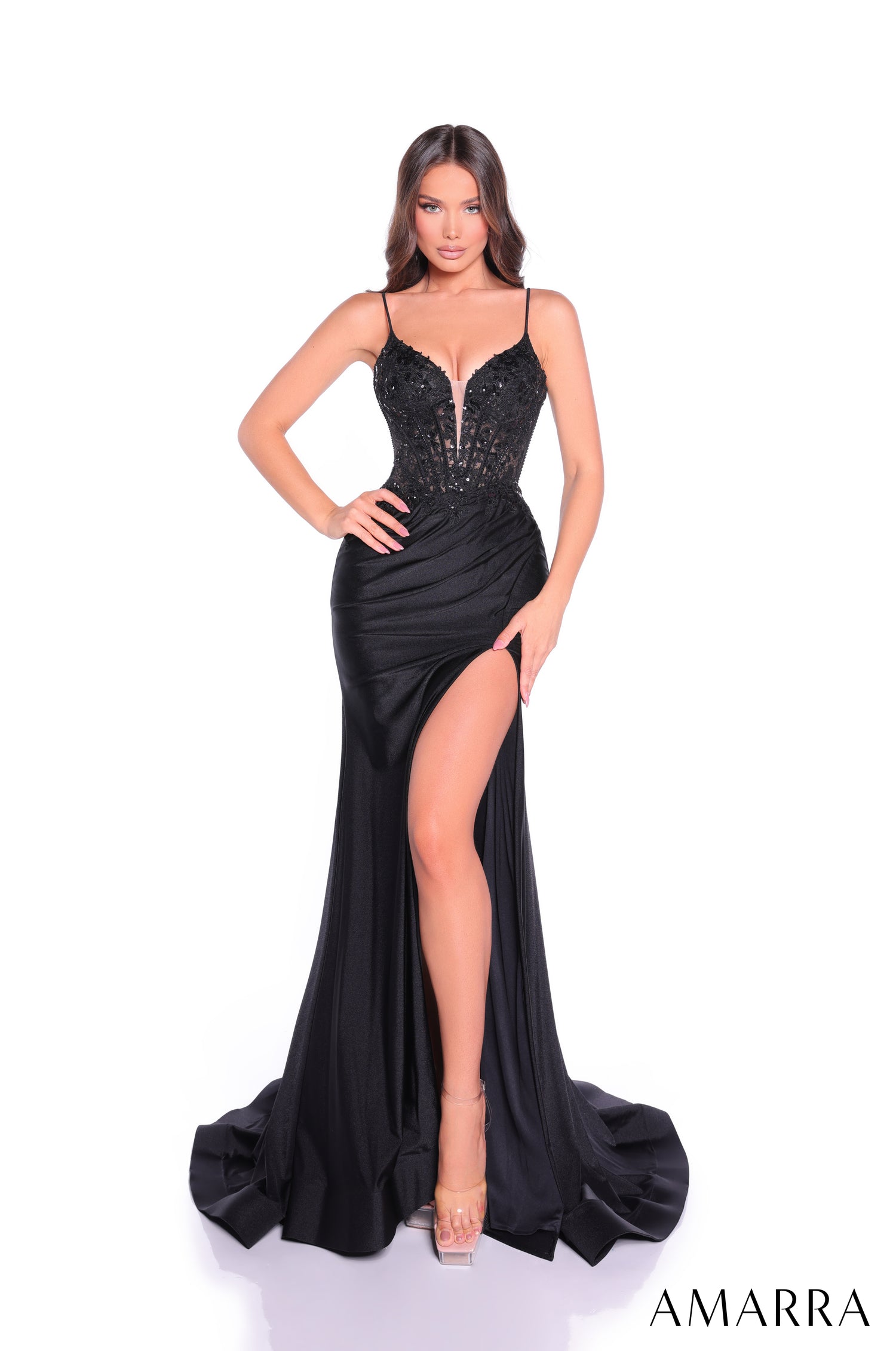 A model wears a black sequined evening gown with a thigh-high slit and dramatic train.