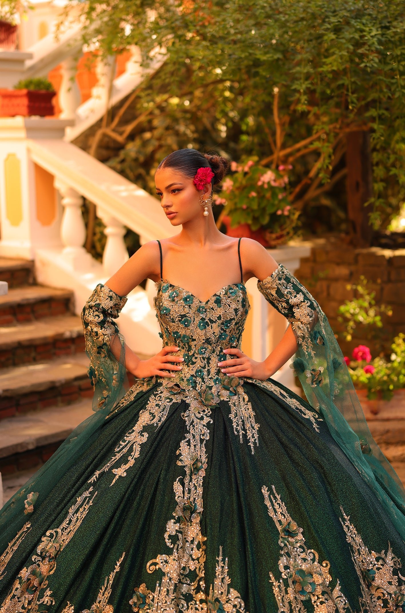 Emerald green ball gown with gold embroidery features sweetheart neckline and dramatic skirt in garden setting.