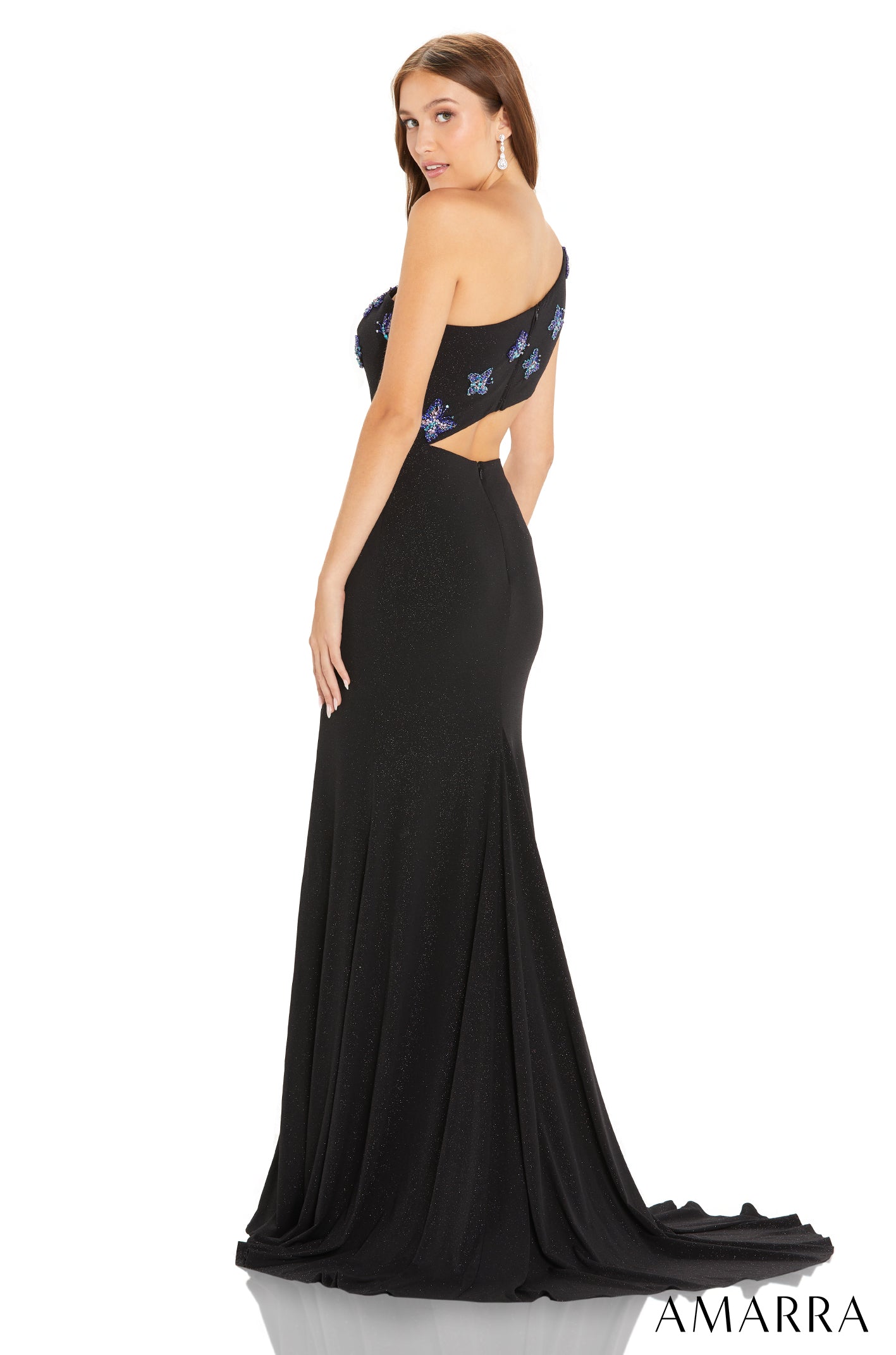 Black one-shoulder evening gown with blue floral embellishments and a cutout waist, flowing to a long train.
