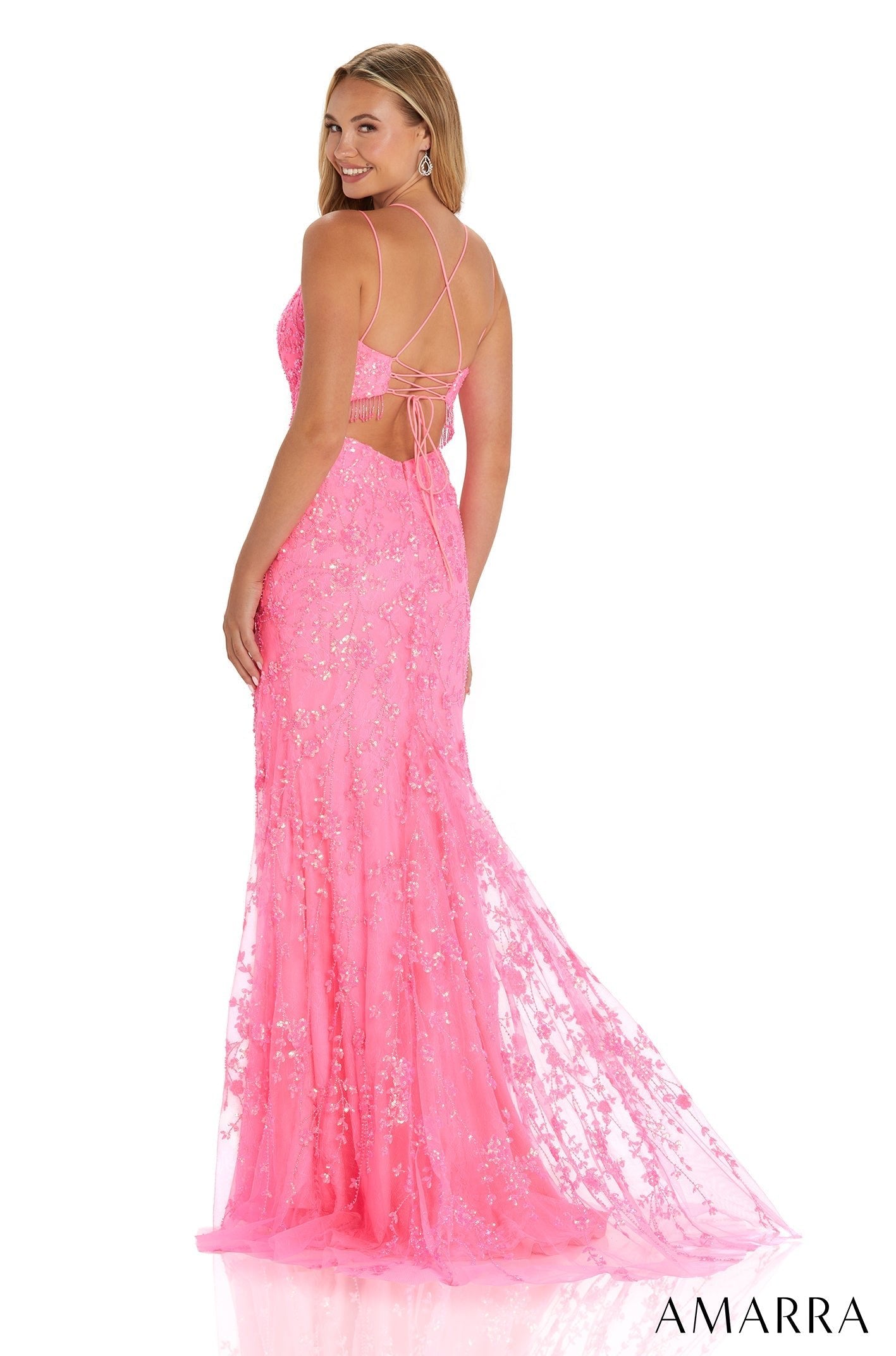 A bright pink sequined mermaid gown with criss-cross back, worn by a woman facing away from the camera.