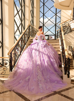 A lavender ball gown with floral embellishments cascades dramatically on an ornate staircase with large windows.