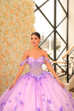 A woman wears a lavender ball gown with 3D floral details and a sheer corset bodice against a flower wall.