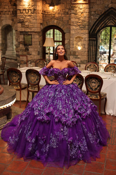 A woman in a voluminous purple ball gown with floral embellishments stands in an elegant stone-walled dining room.