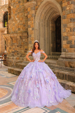 A woman wears a voluminous lilac ball gown with 3D floral details, standing in front of a stone castle entrance.