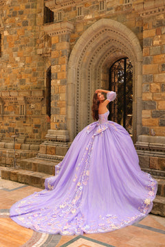 A woman in a lavender ball gown poses dramatically on stone steps by an arched castle doorway.