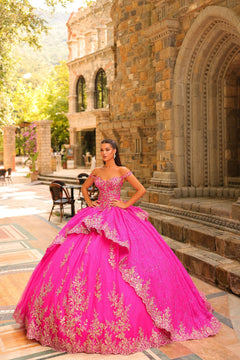 A woman in a fuchsia ball gown with gold lace stands before a stone architectural backdrop.
