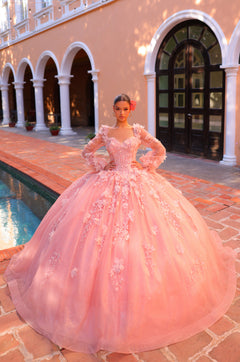 A blush pink, elaborate ball gown with 3D floral details sits on a model near arched columns and a pool.