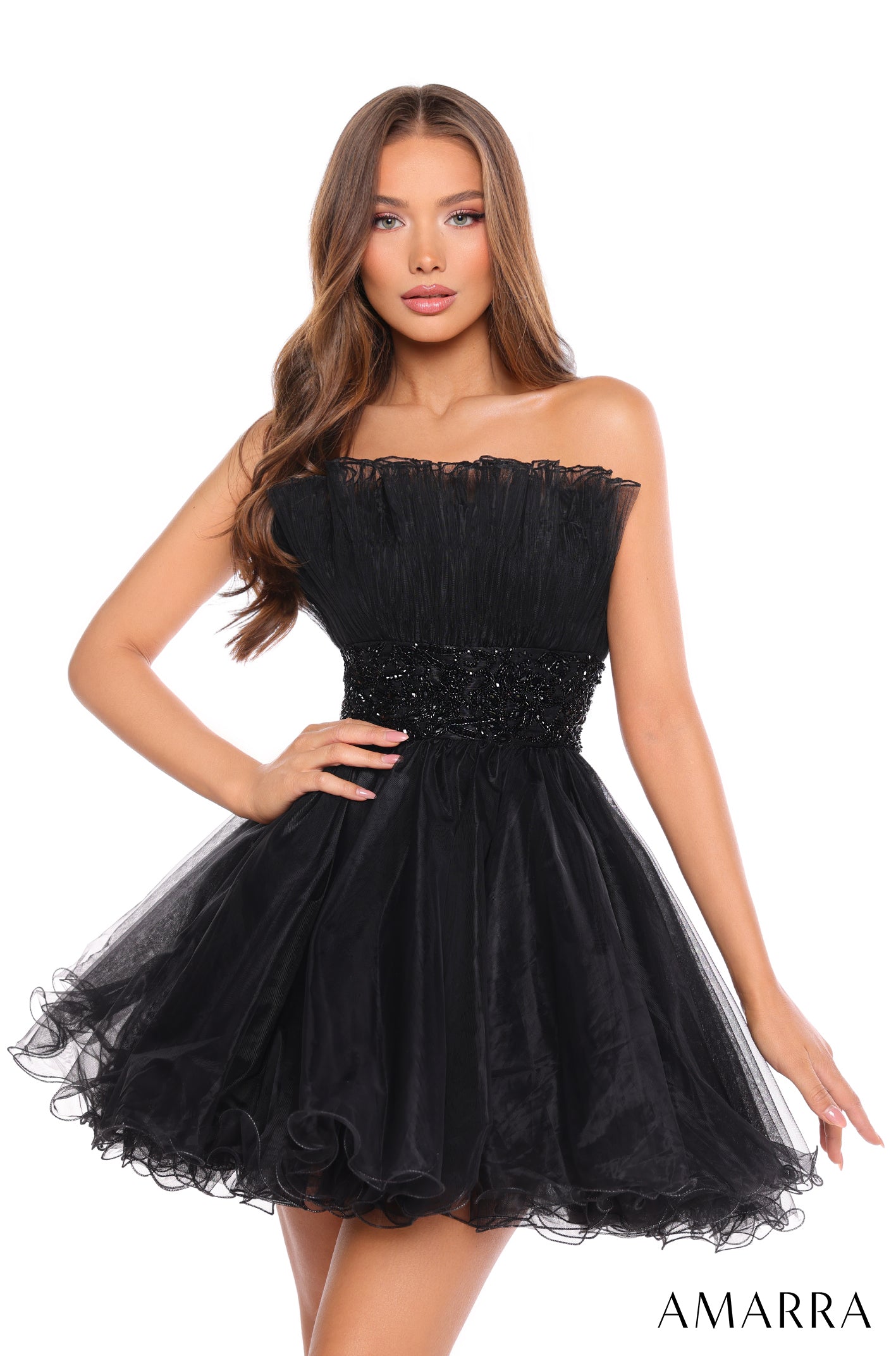 A model wears a strapless, ruffled Black tulle cocktail dress with a beaded waistband by Amarra.