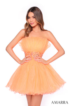 A model wears a strapless, ruffled Dreamsicle tulle dress with a beaded waistband.