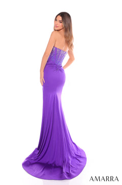 A person in a shimmering purple strapless mermaid-style gown with a sparkling corset bodice and long train.