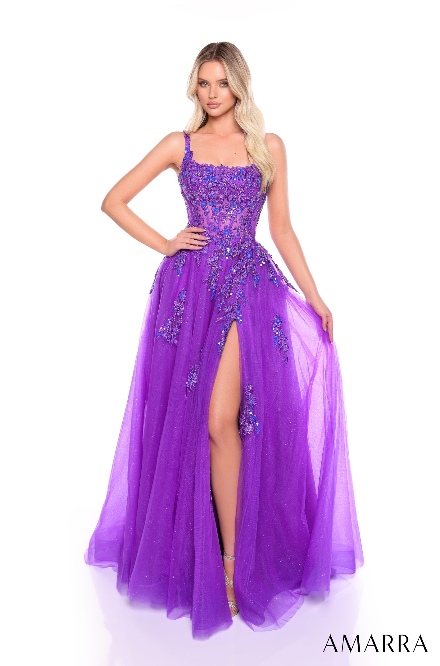 A model wears a floor-length Purple tulle gown with beaded bodice and high side slit by Amarra.