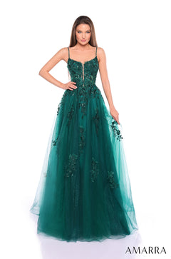 A slender model wears an emerald green floor-length gown with intricate beaded floral appliqués and a fitted bodice.