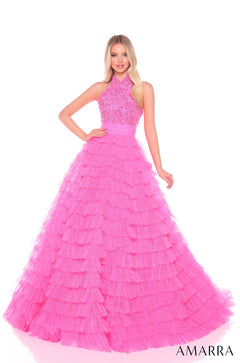 A woman wears a tiered, ruffled Hot Pink ball gown with a beaded halter top by Amarra.