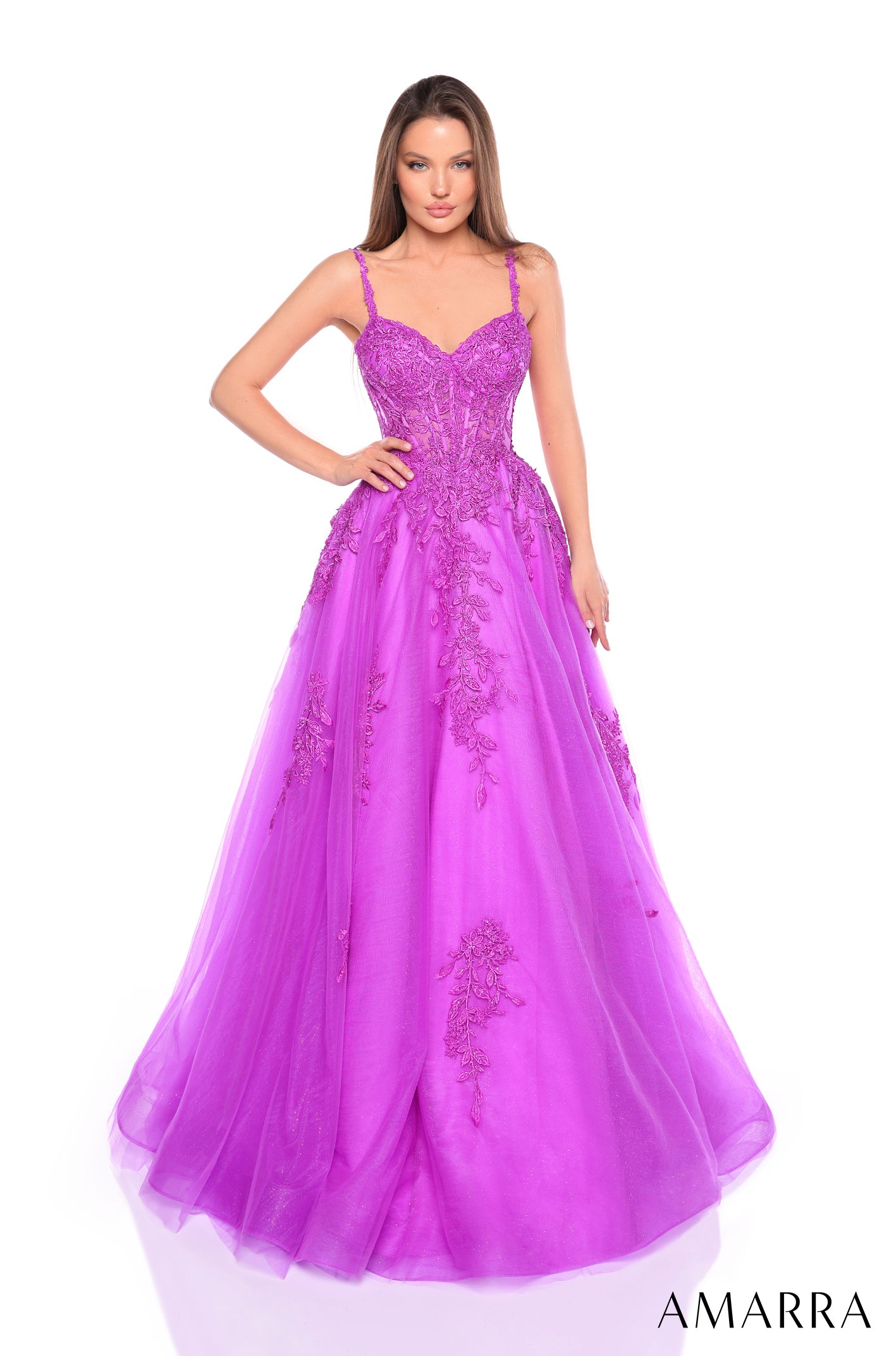 A woman wears a lavish Purple ball gown with floral lace details and spaghetti straps by Amarra.
