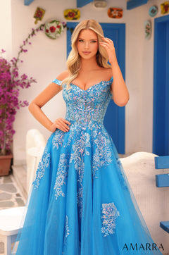 A blue off-shoulder ball gown with floral embroidery, styled against a white and blue Mediterranean-style backdrop.