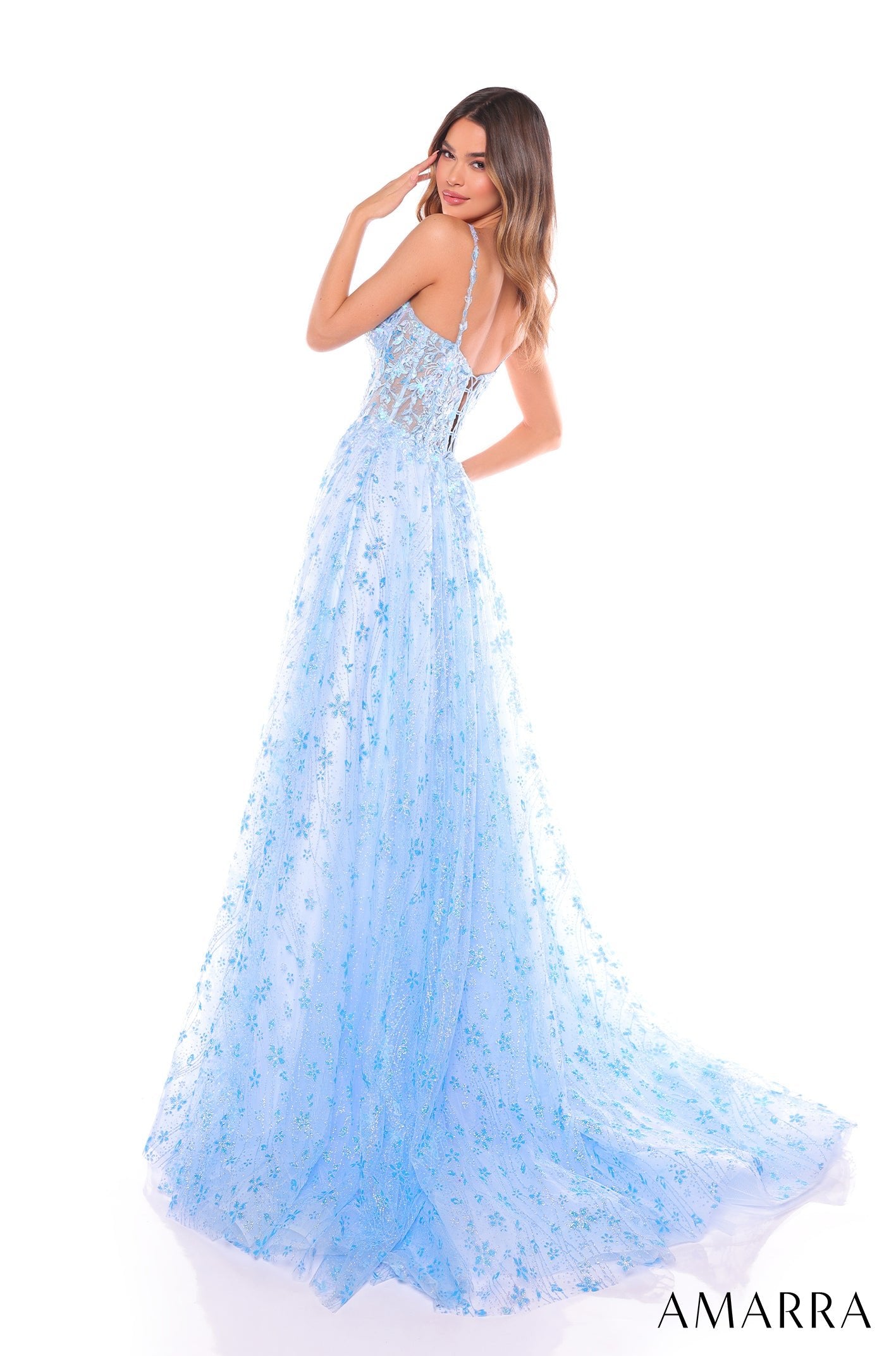 A light blue floral tulle gown with a corset bodice and flowing skirt, worn by a model posing sideways.