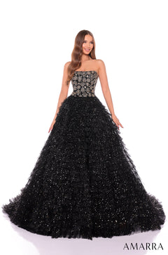 A model wears a strapless Black/Gold ballgown with sparkling tulle skirt and embellished bodice.