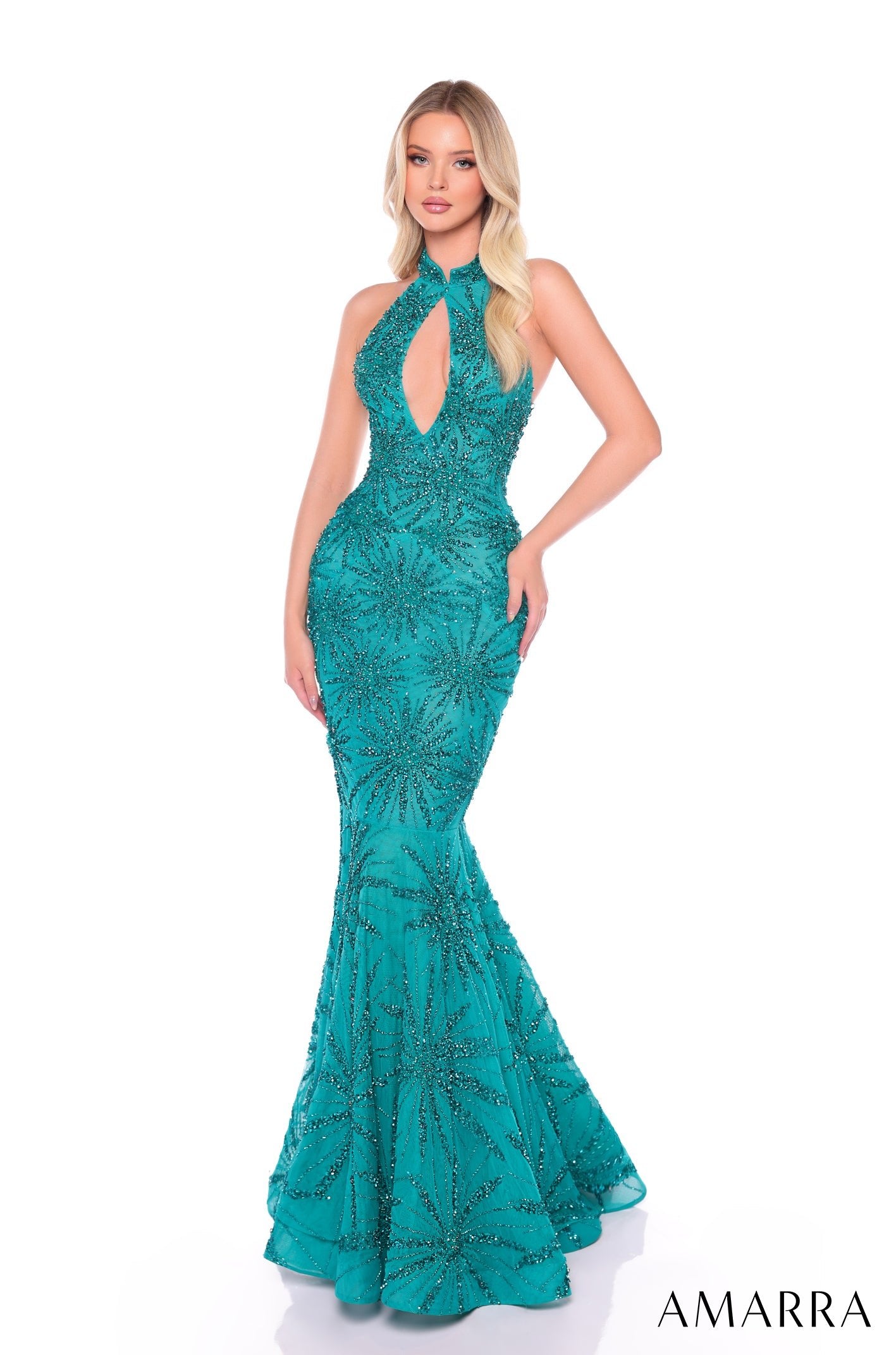 A model wears a jade mermaid-style evening gown with intricate starburst beading and a keyhole neckline.
