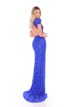 A woman wears a royal blue, floor-length sequined gown with a backless design and short sleeves.