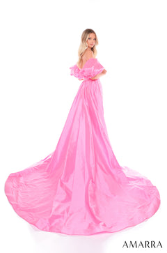 A blonde woman wears a voluminous, bright pink off-shoulder ball gown with a long, flowing train.
