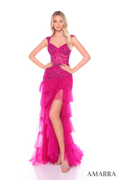 A woman wears a tiered, sequined bright fuchsia gown with a high slit and intricate bodice.