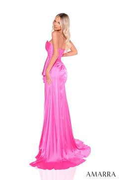 A blonde woman wears a vibrant pink strapless satin gown with a dramatic train and fitted silhouette.