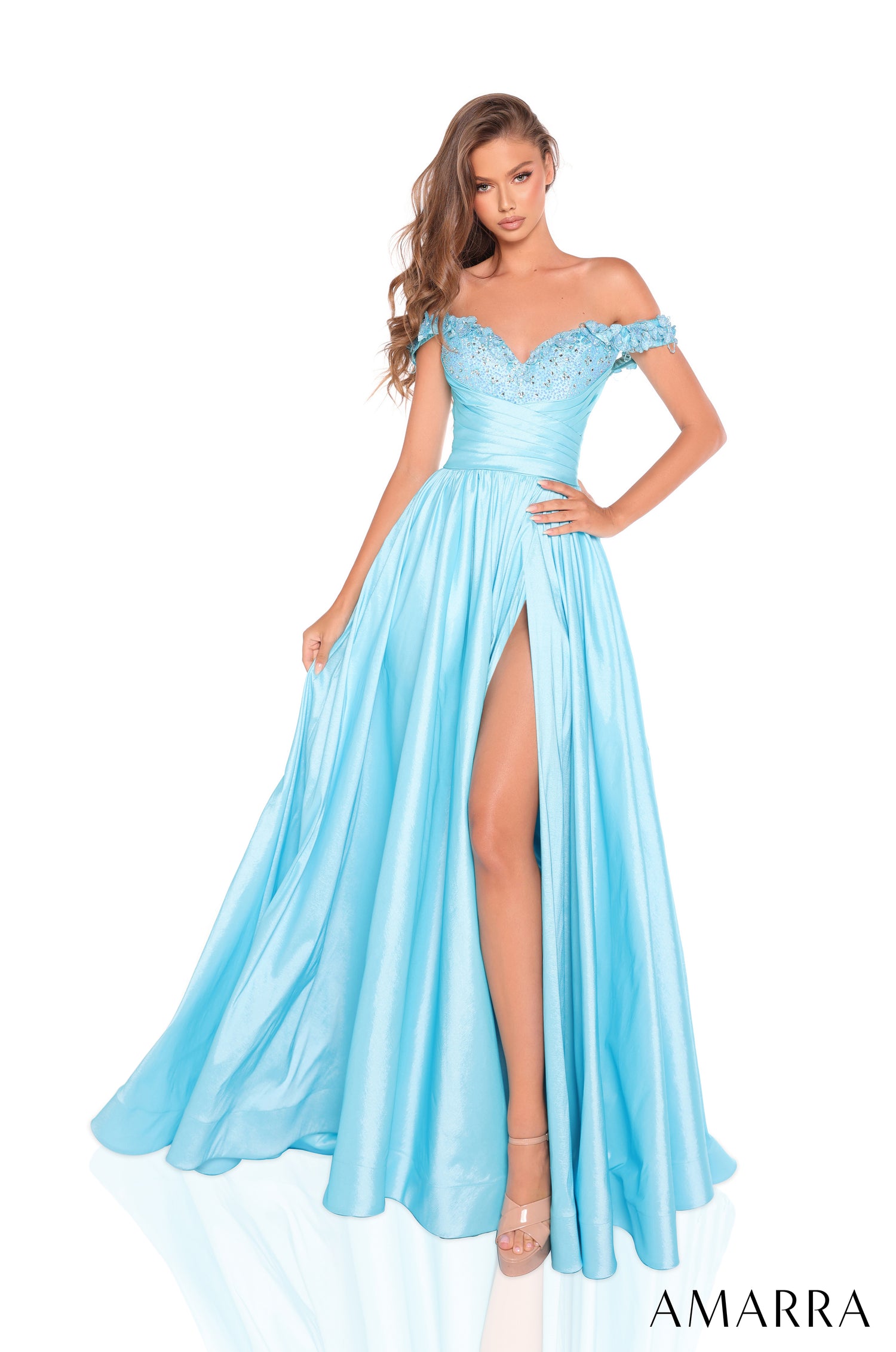 A model wears a turquoise off-shoulder gown with beaded bodice and high slit on white background.