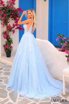A woman in a light blue, lace ballgown poses amid vibrant pink bougainvillea flowers with blue doors.