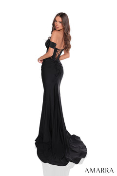 A slim-fitted black off-shoulder gown with a corset back and long train, worn by a model facing sideways.